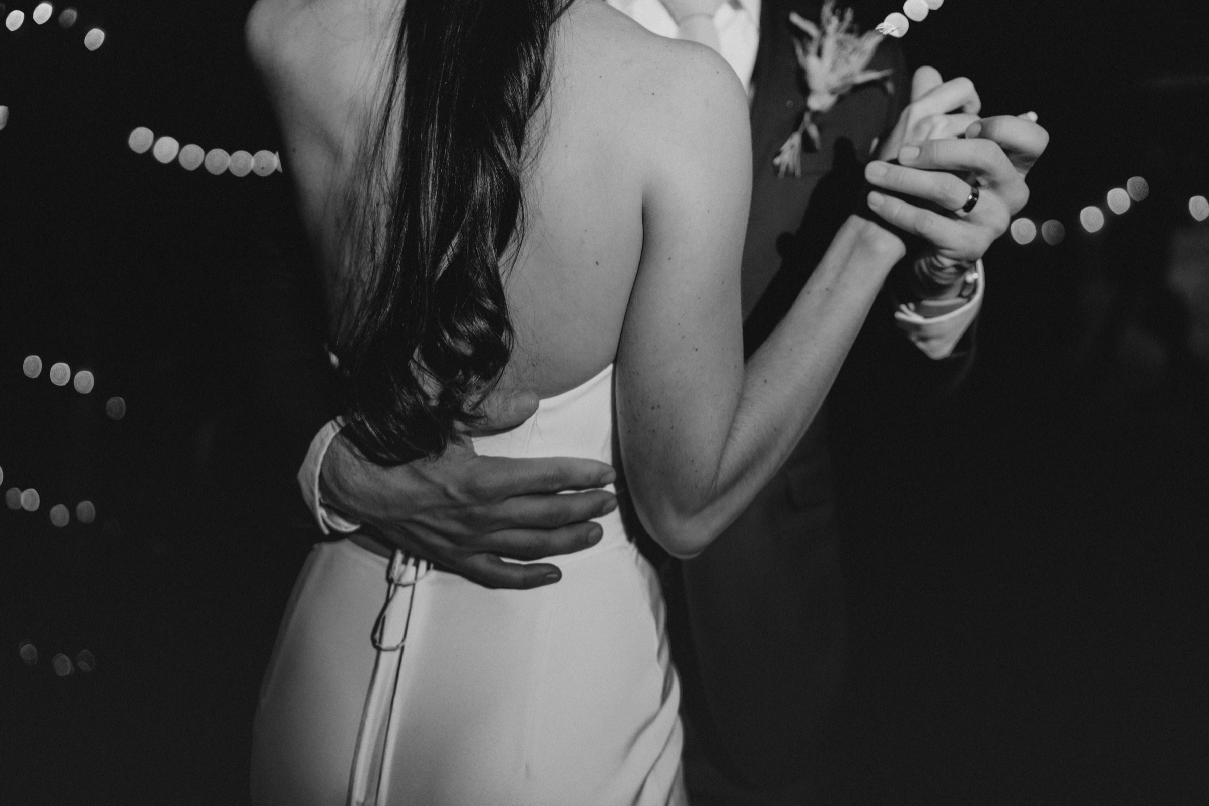 A close view of a couple holding one another during their first dance