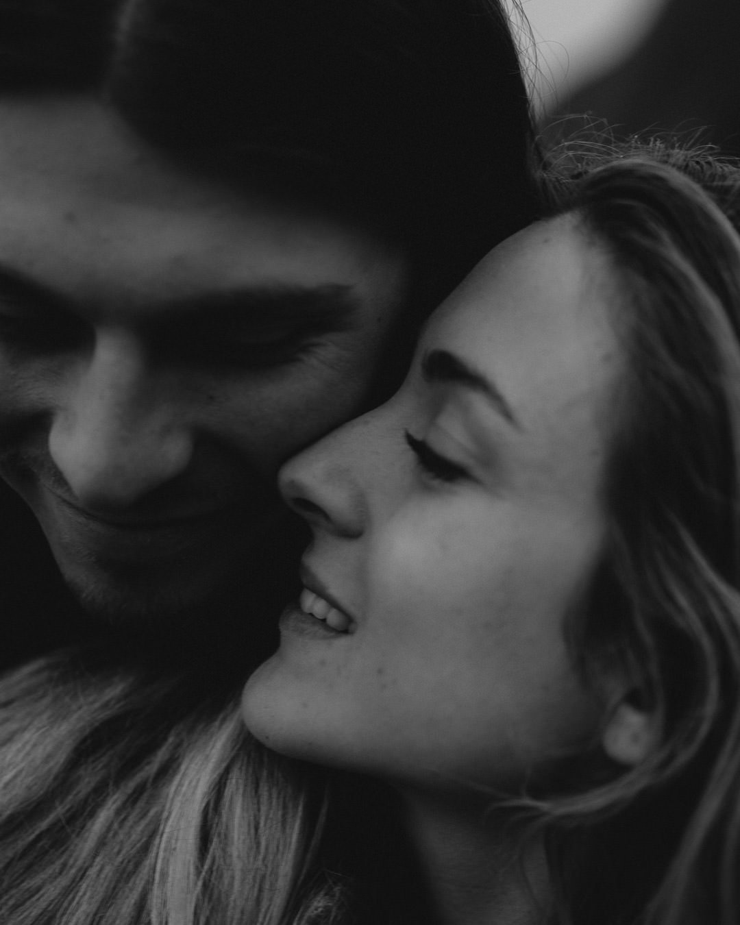 Hannah and Clay holding one another in a close black-and-white portrait