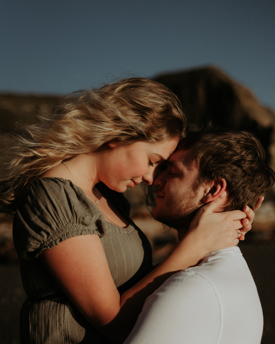 Gabe and Alena leaning close in warm evening light