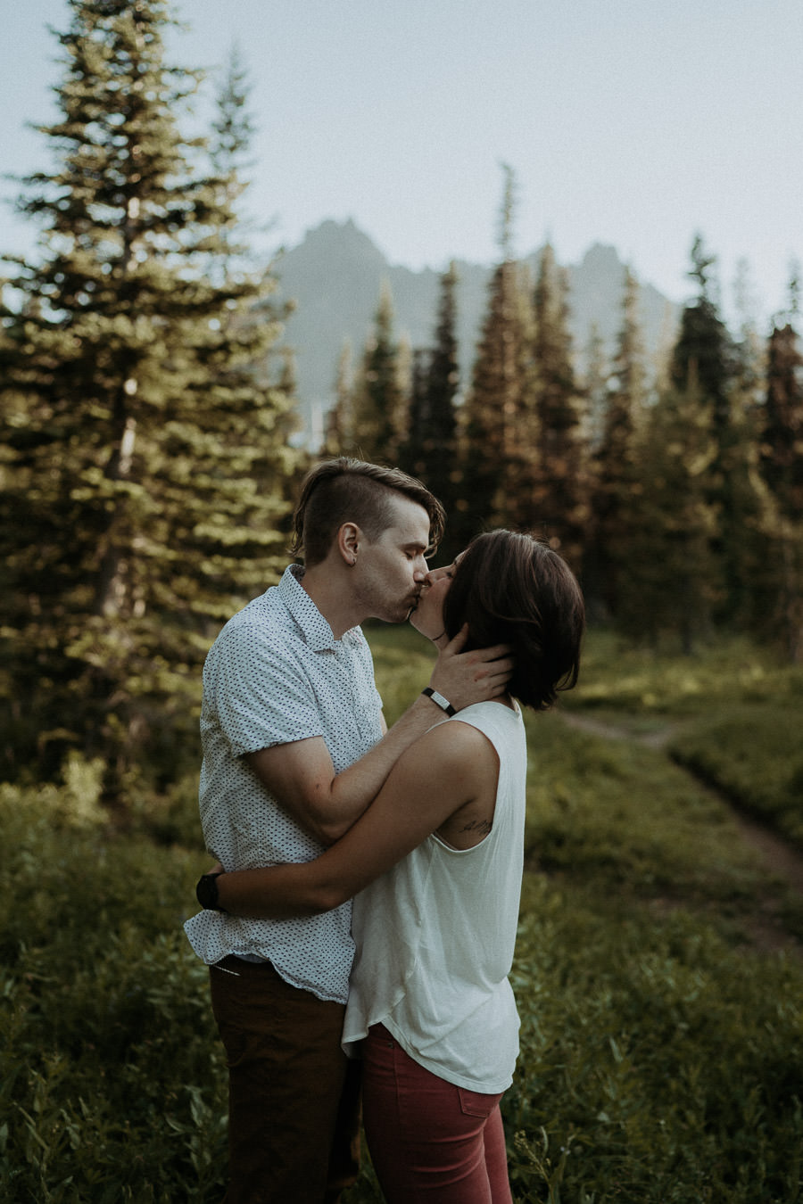 Larry and Alison kissing in a sunlit Oregon forest