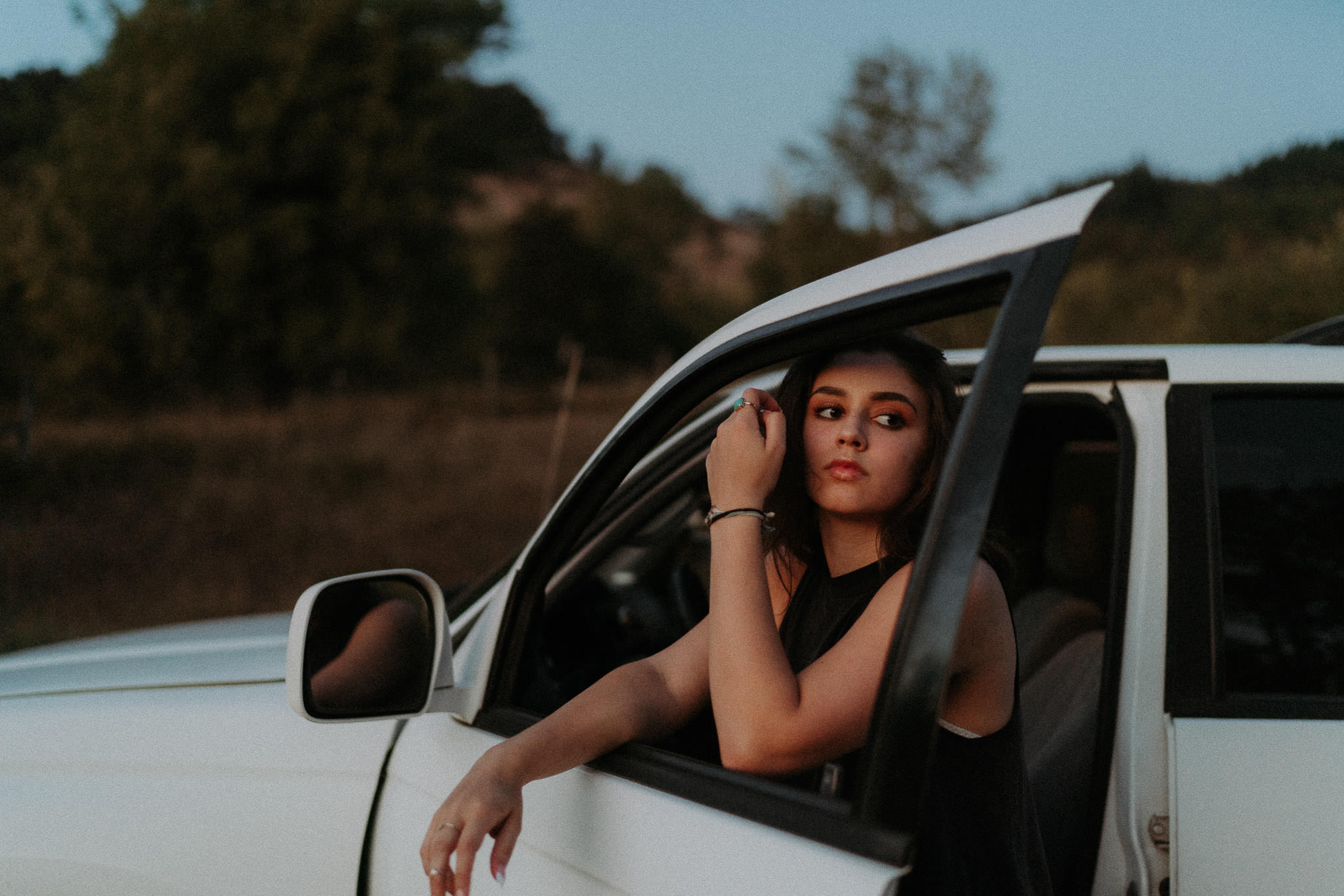 A woman leaning out of a car window during an outdoor portrait session